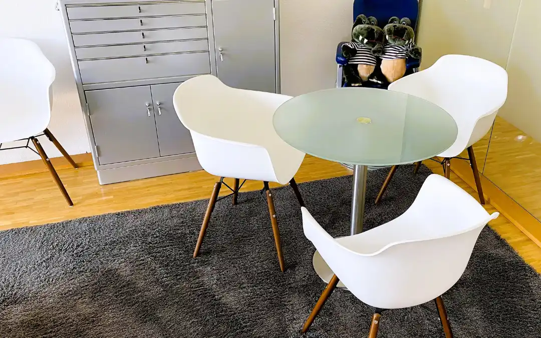 Helle, bequeme Stühle mit rundem Glastisch im Wartebereich der KFO Kaufhold