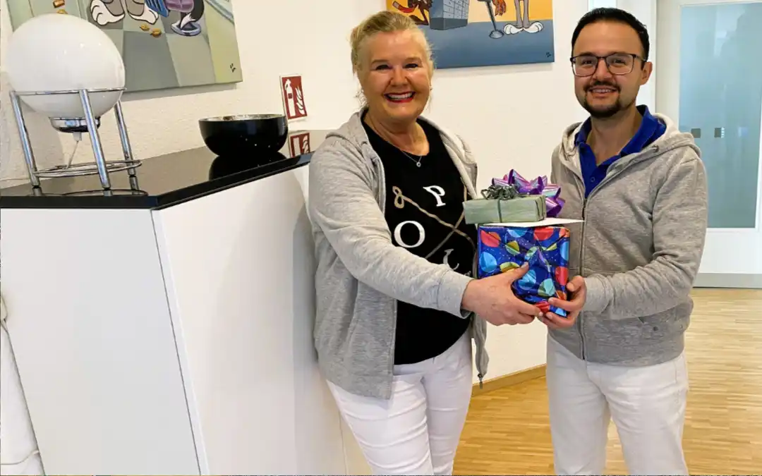 Iris Kaufhold, Fachzahnärztin für Kieferorthopädie, gratuliert Assistenzzahnarzt Ammar Moussellie zur bestandenen Prüfung zum Fachzahnarzt für Kieferorthopädie in der Praxis KFO Kaufhold