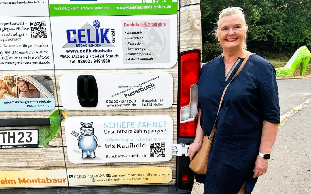 Iris Kaufhold vor dem neuen Fahrzeug des Tierheims Montabaur mit Praxiswerbung der Kieferorthopädischen Fachpraxis Iris Kaufhold